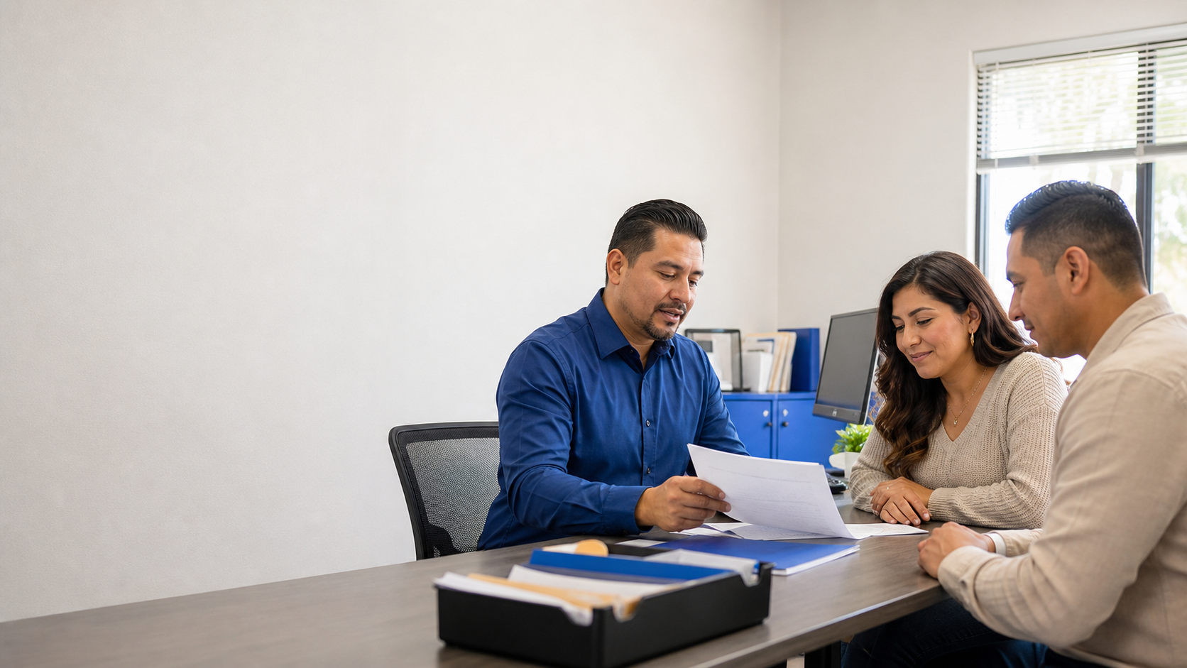 A tax professional reviewing documents with clients in a neighborhood office